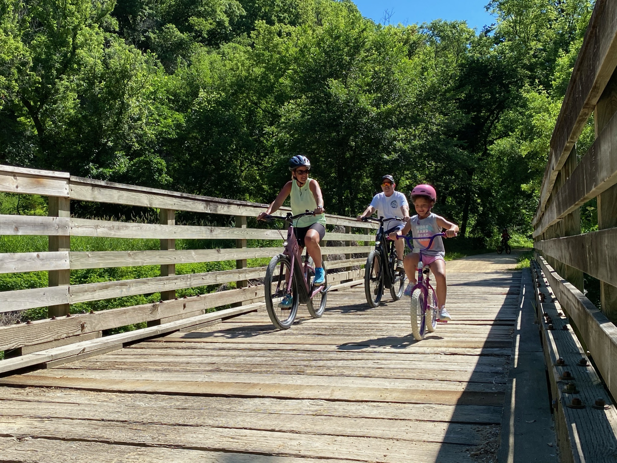 Family Riding a Dubuque E-Bike on a Trail Bridge