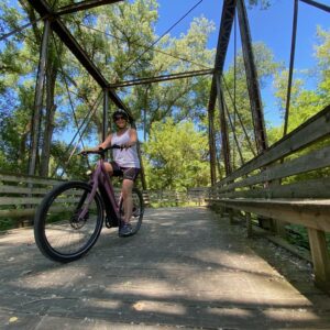 Woman Riding a Dubuque E-Bike on a Trail Bridge