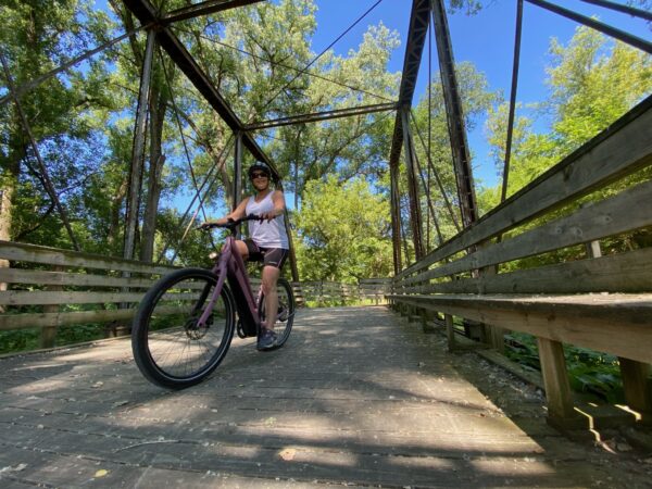 Woman Riding a Dubuque E-Bike on a Trail Bridge